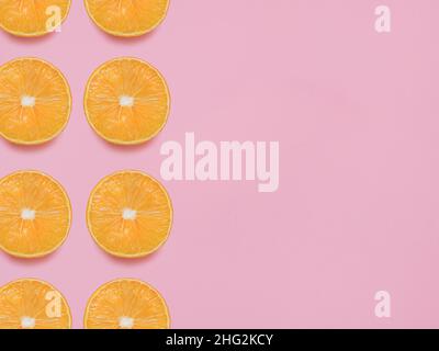 Orangenhälften auf pastellrosa Hintergrund Stockfoto