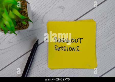 Breakout Sessions schreiben auf Haftnotizen isoliert auf Holztisch. Stockfoto