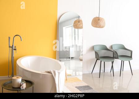 Stilvolle Einrichtung des Badezimmers mit großem Spiegel und moderner Badewanne Stockfoto