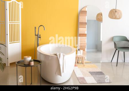 Moderne Badewanne und großer Spiegel im Badezimmer Stockfoto