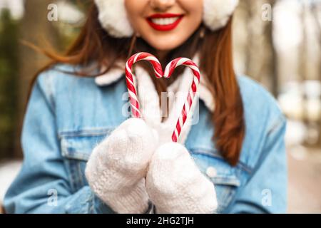 Junge Frau in Fäustlingen mit Zuckerstöcken, Nahaufnahme Stockfoto