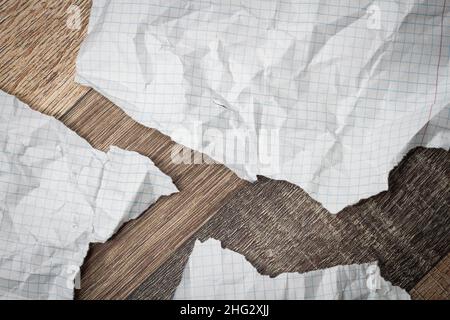 Zerknittertes und zerrissenes Papier auf dem Tisch. Zerrissenes Notizbuch. Papiermüll. Voller Korb mit Notizen. Notizblock und Bleistift auf zerknittertem Papierhintergrund. Stockfoto
