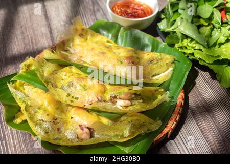 Banh Xeo ist ein traditioneller vietnamesischer Kuchen. Kuchen Zutaten sind Mehl, Garnelen, Schweinefleisch, verdrehte Knollen, Tintenfisch ... und Gemüse, um die cak begleiten Stockfoto