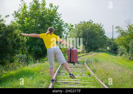 Rücksichtsloser Passagier läuft an den Senkern hinter dem Zug entlang Stockfoto