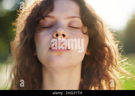 Ein Portraitfoto eines Ingwermädchen mit geschlossenen Augen Stockfoto