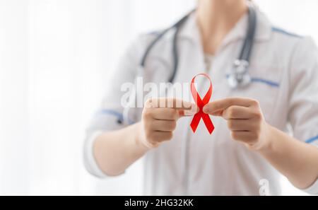 Welt-Aids-Tag. Rotes Band in den Händen Nahaufnahme Stockfoto