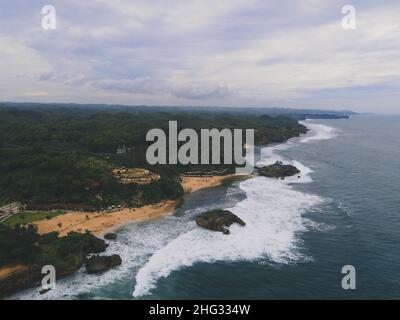 Luftaufnahme des Strandes von Baron in Yogyakarta, Indonesien mit Leuchtturm und traditionellen Booten Stockfoto