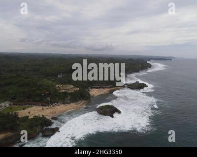 Luftaufnahme des Strandes von Baron in Yogyakarta, Indonesien mit Leuchtturm und traditionellen Booten Stockfoto