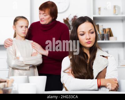 Mutter verärgert nach Streit mit Tochter hinter mit Großmutter stehen Stockfoto