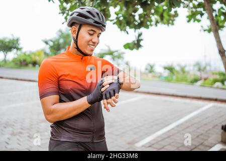 Der junge Radfahrer überprüft nach dem Reiten seinen Trainingsfortschritt Stockfoto