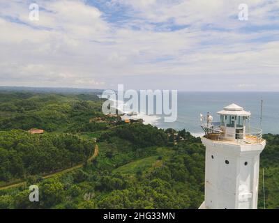 Luftaufnahme des Strandes von Baron in Yogyakarta, Indonesien mit Leuchtturm und traditionellen Booten Stockfoto