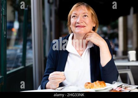 Ältere Frau trinkt Kaffee im Café Stockfoto