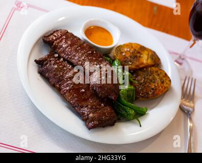 Gegrilltes Rinderfilet mit gebackenen Kartoffeln, grünen Paprika und Chimichurri-Sauce Stockfoto