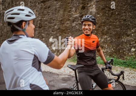Zwei Radfahrer Freund hoch fünf, als er sein Rennen zusammen beenden Stockfoto