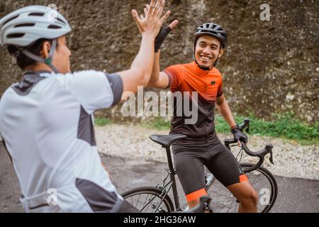 Zwei Radfahrer Freund hoch fünf, als er sein Rennen zusammen beenden Stockfoto