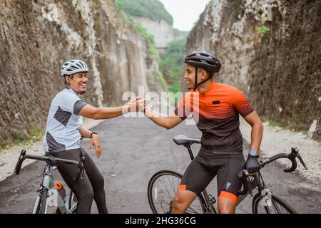 Zwei Radfahrer Freund hoch fünf, als er sein Rennen zusammen beenden Stockfoto