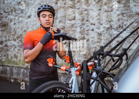 Junger Mann, der im Freien seinen Sporthelm trägt Stockfoto