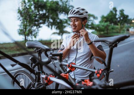 Junger Mann, der im Freien seinen Sporthelm trägt Stockfoto