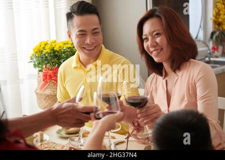 Glückliche Familie, die zu Hause traditionelles Tet-Abendessen genießt Stockfoto
