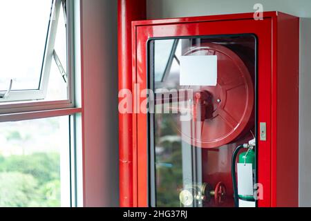Die Schränke der Brandschutzanlage sind mit dem Notfall geregelt Feuerlöscher und Walzrohr Stockfoto