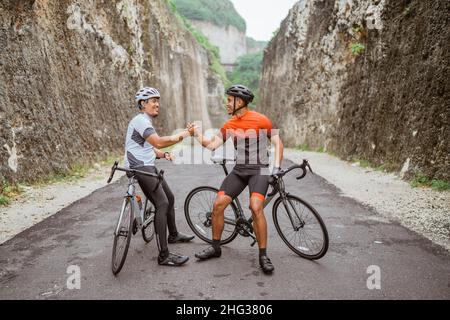 Zwei Radfahrer Freund hoch fünf, als er sein Rennen zusammen beenden Stockfoto