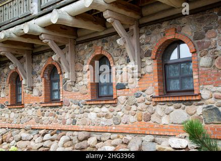 Es gibt viele halbrunde Holzfenster im Steingebäude. Konzept des architektonischen Denkmals, Festung Stockfoto