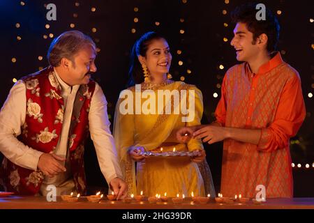 Porträt einer indischen Familie, die mit Diyas anlässlich von Diwali feiert Stockfoto