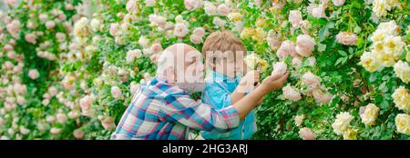 Großvater und Enkelkind, Frühlingsbanner. Alt und Jung. Konzept eines Rentenalters. Kleiner Helfer im Garten. Stockfoto