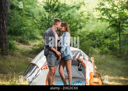 Paar camping in der Nähe von Wald Hintergrund. Natur- und Lifestyle-Konzept. Romantische Liebhaber auf dem Land. Paare, die im Sommer im Wald campen. Stockfoto