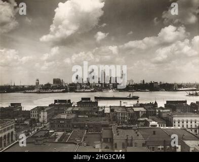 Vintage-Foto der Skyline von Detroit. Skyline von Detroit und Boote auf dem Detroit River aus Sicht von Windsor, Ontario(?). Im Vordergrund, Dächer des Gebäudes Stockfoto