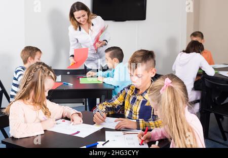 Gruppe von Kindern im Elementaralter Zeichnung im Klassenzimmer Stockfoto