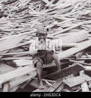 Archivfoto des Hurrikans Galveston 1900. Ein überlebender afroamerikanischer Junge sitzt inmitten der Trümmer, die durch den Hurrikan verursacht wurden. Galveston, Texas. USA. Okt Stockfoto