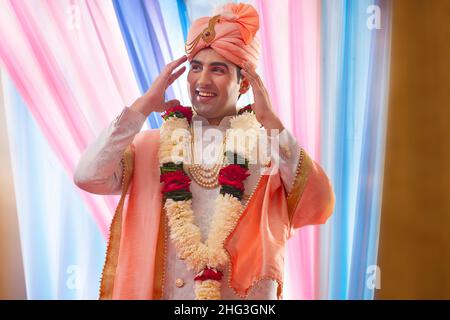 Portrait eines gutaussehenden Bräutigams, der in einem reichen indianischen Stil für die Hochzeit gekleidet ist Stockfoto