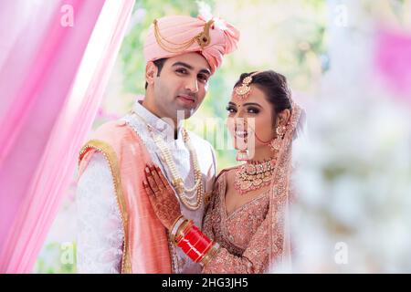 Porträt eines indischen Ehepaars, das vor der Kamera posiert, um ein Fotoalbum zu machen Stockfoto