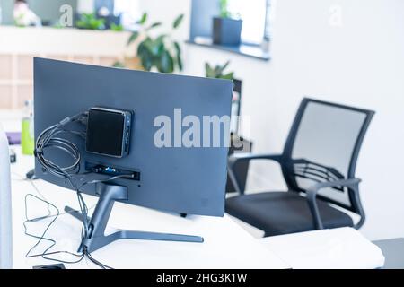 Eine kurze Aufnahme eines tragbaren Büroschreibtisches mit Computergeräten, Zubehör und Dekorationen auf einem weißen Tisch. Stockfoto