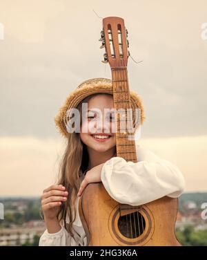 Stilvolle Kind Mädchen spielen Gitarre im Freien, Country-Musik Stockfoto