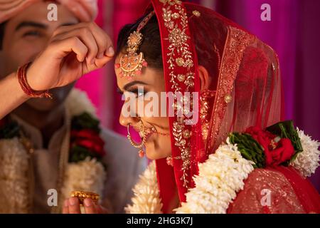 Ehepaar, das während ihrer Hochzeit das Sindoor-Daan-Ritual durchführt Stockfoto