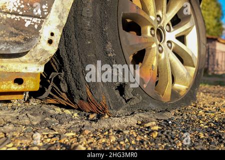 Ein Rad eines ausgebrannten Autos. Reste des Autos. Stockfoto