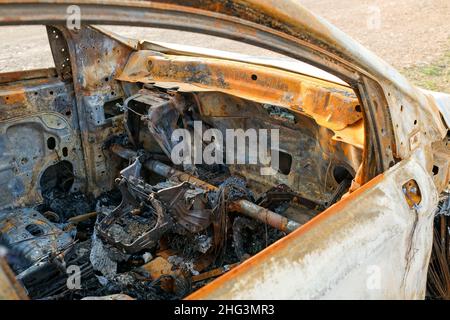 Das Auto nach dem Feuer. Eiserne Teile eines verbrannten Autos. Stockfoto