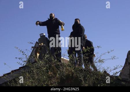 Jerusalem, Israel. 17th Januar 2022. Der Palästinenser Mohammed Salhiya hält eine mit Benzin gefüllte Flasche, während er mit Gasbehältern auf dem Dach des palästinensischen Hauses der Familie Salhiya steht und droht, sich selbst in Brand zu setzen, nachdem Mitglieder der israelischen Sicherheitskräfte das Familienhaus eines Palästinensers, Salhiya, Dies wird am 17. Januar 2021 in Jerusalem, Israel, im Scheich-Jarrah-Viertel gefordert. Salhiyas Familie ist seit 2017 mit einer Räumungsdrohung konfrontiert, als das Land, in dem sich sein Haus befindet, für den Schulbau bestimmt wurde. Das palästinensische Viertel von Sheikh Jarrah Stockfoto