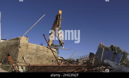 Jerusalem, Israel. 17th Januar 2022. Ein Bagger zerstört eine Struktur auf dem Gelände des Familienhauses eines Palästinensers, Salhiya, das am 17. Januar 2021 in Jerusalem, Israel, im Scheich-Jarrah-Viertel geräumt werden soll. Salhiyas Familie ist seit 2017 mit einer Räumungsdrohung konfrontiert, als das Land, in dem sich sein Haus befindet, für den Schulbau bestimmt wurde. Das palästinensische Viertel Sheikh Jarrah ist derzeit das Zentrum einer Reihe von Eigentumsstreitigkeiten zwischen Palästinensern und rechtsgerichteten jüdischen Israelis. Einige Häuser wurden nach einem Cour von israelischen Siedlern besetzt Stockfoto