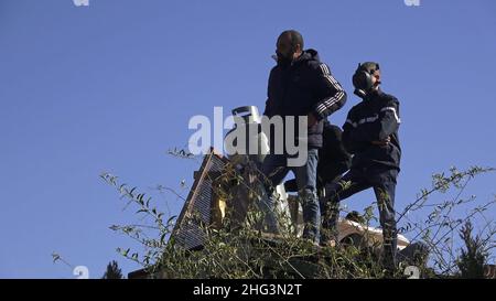 Jerusalem, Israel. 17th Januar 2022. Der Palästinenser Mohammed Salhiya hält eine mit Benzin gefüllte Flasche, während er mit Gasbehältern auf dem Dach des palästinensischen Hauses der Familie Salhiya steht und droht, sich selbst in Brand zu setzen, nachdem Mitglieder der israelischen Sicherheitskräfte das Familienhaus eines Palästinensers, Salhiya, Dies wird am 17. Januar 2021 in Jerusalem, Israel, im Scheich-Jarrah-Viertel gefordert. Salhiyas Familie ist seit 2017 mit einer Räumungsdrohung konfrontiert, als das Land, in dem sich sein Haus befindet, für den Schulbau bestimmt wurde. Das palästinensische Viertel von Sheikh Jarrah Stockfoto