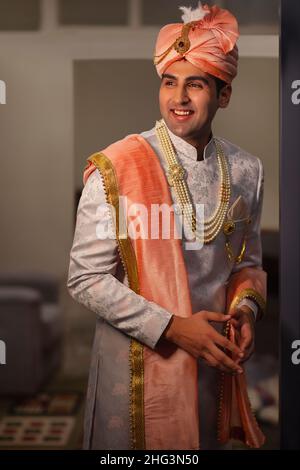 Portrait eines gutaussehenden Bräutigams, der in einem reichen indianischen Stil für die Hochzeit gekleidet ist Stockfoto