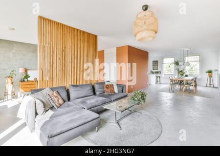 Wunderschöner minimalistischer weißer Wohnbereich mit grauem Sofa Stockfoto