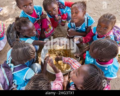 Senegal, Afrika - Jan 2019: Senegalesische Kinder essen in der Schule gemeinsam auf traditionelle Weise. Stockfoto