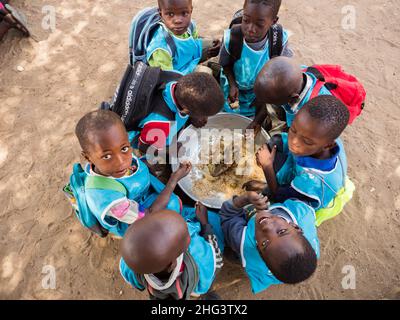 Senegal, Afrika - Jan 2019: Senegalesische Kinder essen in der Schule gemeinsam auf traditionelle Weise. Stockfoto