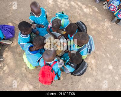 Senegal, Afrika - Jan 2019: Senegalesische Kinder essen in der Schule gemeinsam auf traditionelle Weise. Stockfoto