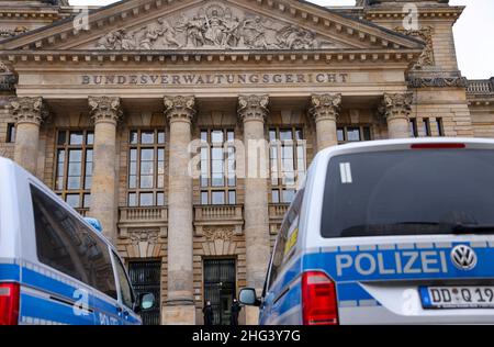 18. Januar 2022, Sachsen, Leipzig: Polizeifahrzeuge stehen vor dem Bundesverwaltungsgericht vor dem Beginn einer Berufungsverhandlung vor dem Strafsenat des BGH 5th wegen eines Mordes in einem Wettbüro. Acht Jahre nach der tödlichen Schießerei in einem Berliner Wettbüro überprüft der Bundesgerichtshof (BGH) die Urteile gegen Mitglieder einer Rocker-Gruppe. Sie stürmten angeblich 2014 in die Kneipe und schossen einen 26-jährigen Mann. Das Landgericht Berlin hatte acht Angeklagte wegen Mordes zu lebenslanger Haft und den Rocker-Führer zu lebenslanger Haft wegen Anstiftung zum Murren verurteilt Stockfoto