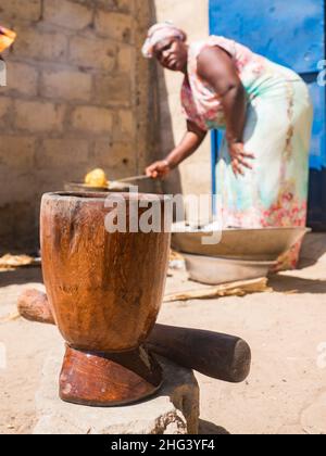 Senegal, Afrika - Jan, 2019: Senegalesische Frau in einer traditionellen Tracht namens 'boubou', die das Essen im afrikanischen Haus kocht. Stockfoto