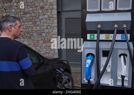 Der Fahrer zahlt, um sein Auto an einer EV-Ladestation in bristol England zu laden Stockfoto